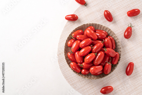 Fresh cherry tomatoes over white table background.