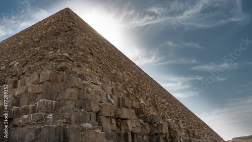The ancient Egyptian pyramid of Cheops against the blue sky. Close-up. The masonry of the wall is visible: huge weathered boulders. Copy Space