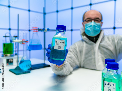 Fototapeta Scientist in the laboratory with a bottle of synthetic fuel in his hand