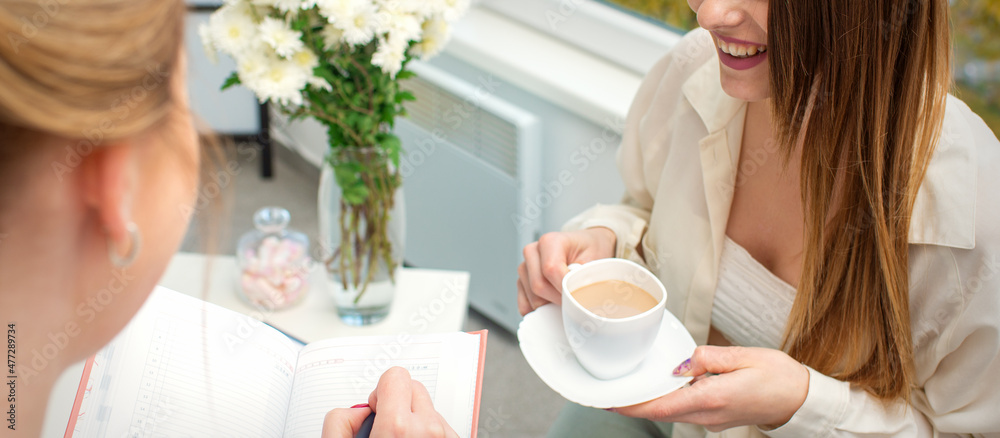 The young caucasian woman has a coffee and appointment with a female doctor in hospital office The young caucasian woman has a coffee and appointment with a female doctor in hospital office