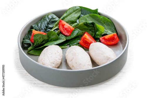 Steamed cutlets of three kinds of white meat with fresh spinach and tomatoes.