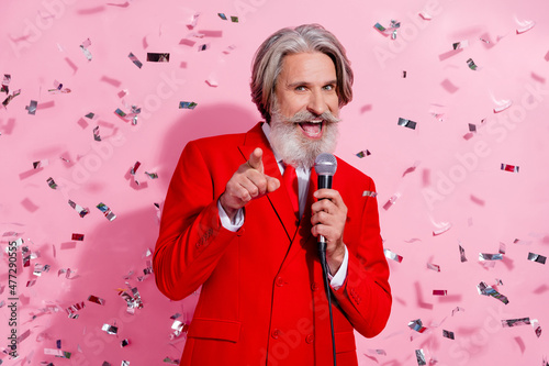 Portrait of attractive cheery trendy grey-haired man mc singing song anniversary congratulate isolated over pink pastel color background photo