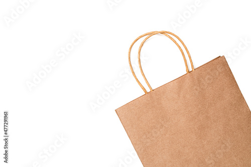 Kraft paper gift or shopping bag against white background. Table top view, flat lay, copy space.
