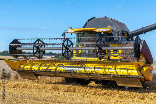 Obraz na plátně La moisson d'un champ de blé avec une moissonneuse batteuse