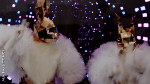 girls are dancing with a large mirrored rabbit mask on a sparkling background. great clip for disco, party and events. Happy new year and christmas photo