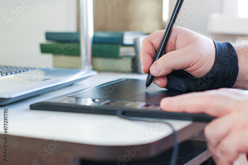 artists hands drawing on a graphics tablet