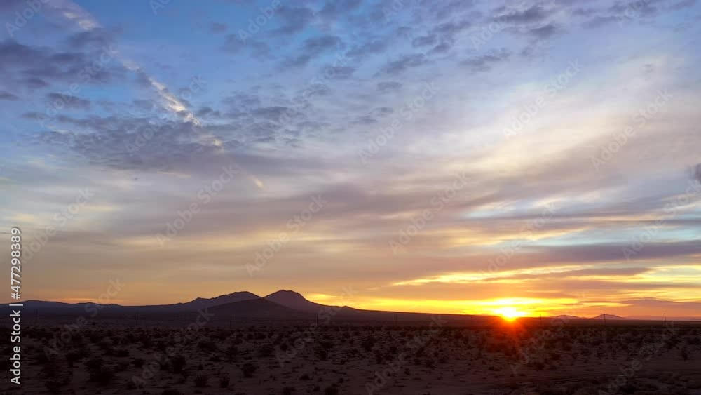 Perfect romantic view of the Mojave Desert during a golden sunset or sunrise - pull back wide angle scenic view with the mountains in silhouette Perfect romantic view of the Mojave Desert during a golden sunset or sunrise - pull back wide angle scenic view with the mountains in silhouette