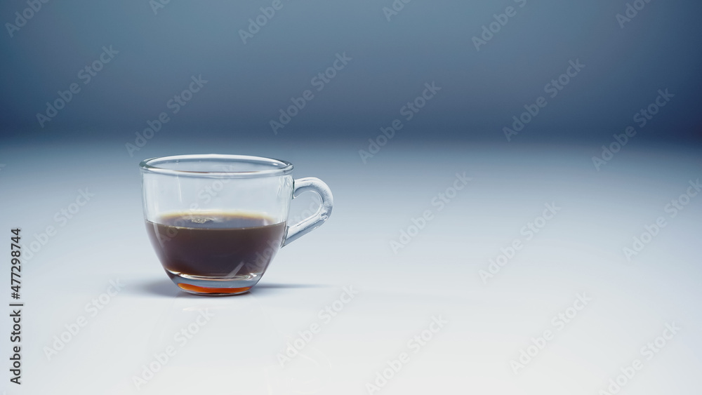 prepared espresso in glass cup on white and grey. prepared espresso in glass cup on white and grey.