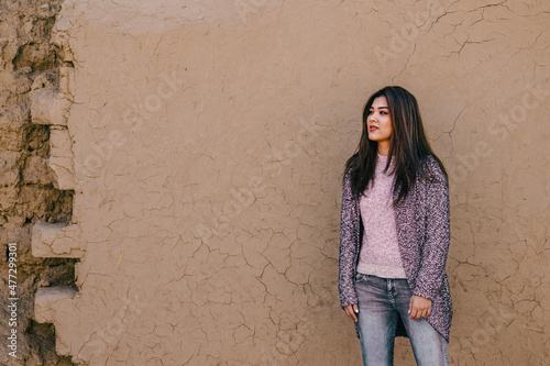 portrait of a girl in front of an ancient cracked wall