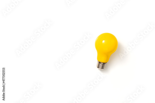 Yellow lightbulb against white background. Creativity, innovation, inspiration, imaginativeness or cleverness concept. Top view, flat lay, copy space.