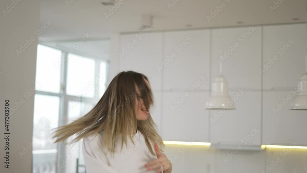 Funny playful blonde woman dancing and singing at home having fun, use remote controller as a microphone Funny playful blonde woman dancing and singing at home having fun, use remote controller as a microphone