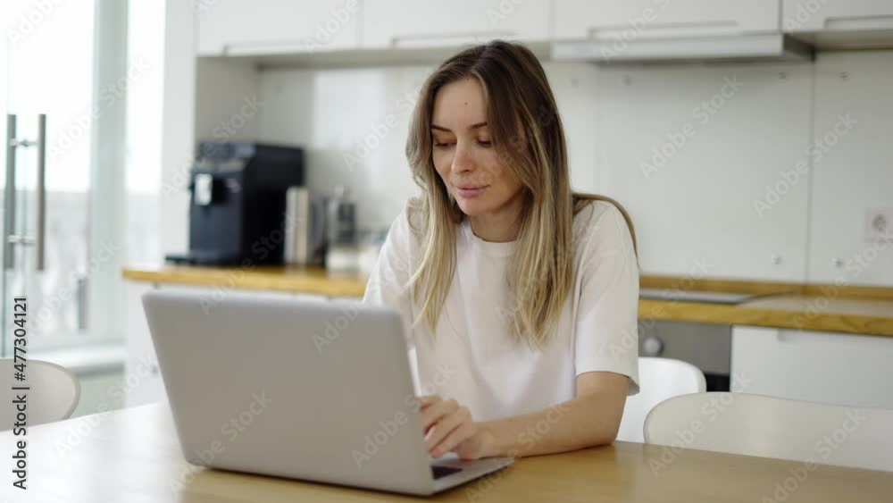 Smiling woman reading good news or surfing internet on laptop