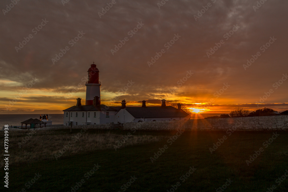 The red and white striped, 23 meter tall,  Souter Lighthouse and the Leas in Marsden, South Shields, England, as the sun rises