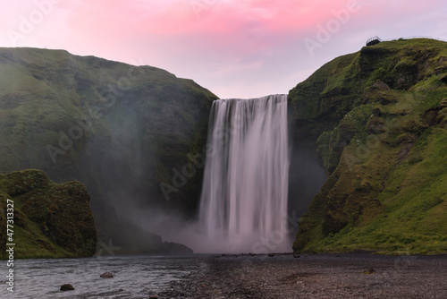 View of a majestic waterfall at dusk in summer. Skogafoss, Iceland.