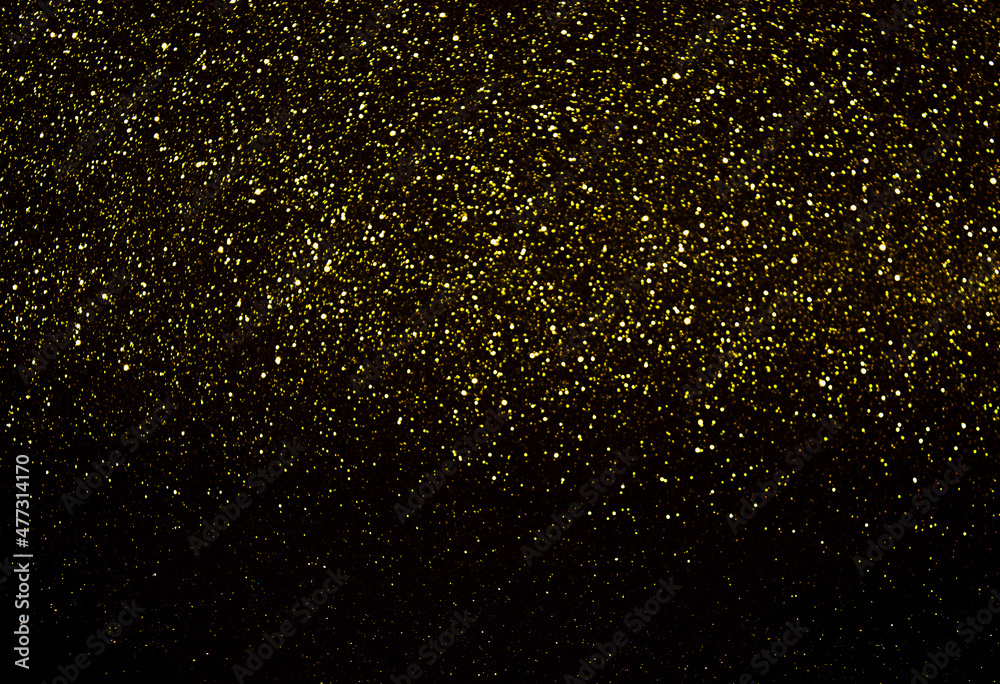 yellow sparkles on a black background. Abstract background
