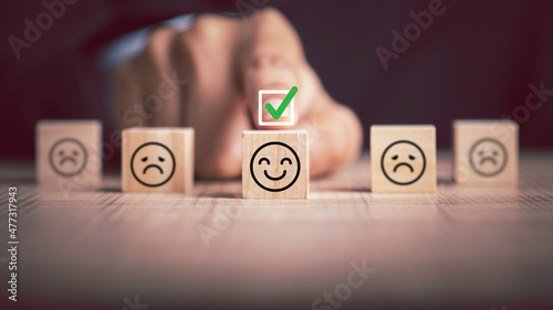 Feedback from customers The check was on a happy face in wood block. Received excellent customer evaluation very satisfied positive customer review concept.