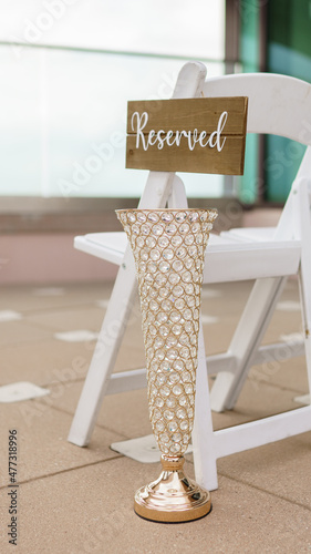 Fotografiet Reserved sign hanging on the white wooden chair Mariage ceremony concept Closeup