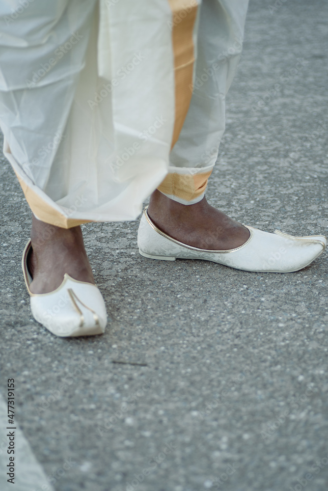 White shoes and legs of an Asian groom in White traditional wedding