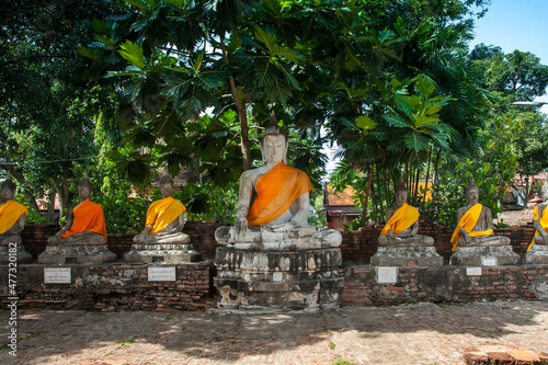 Aligned Sitting Buddha Statues at Wat Yai Chaimongkol in Ayutthaya, the 13 century historic capital of Kingdom of Siam, Thailand photo