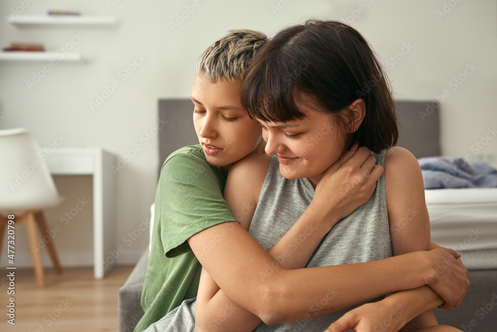 Young lesbian couple resting and hugging at home Young lesbian couple resting and hugging at home