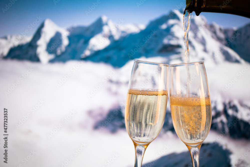 champagne glasses  and snowy peaks in background  New Year