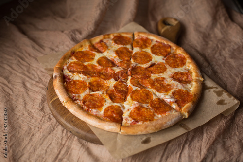 Delicious, aromatic, hot pepperoni pizza on brown background