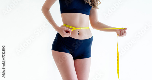 Close-up of a woman in a navy dress Slim figure measured around the waist and torso. Healthy nutrition and weight loss concept.
