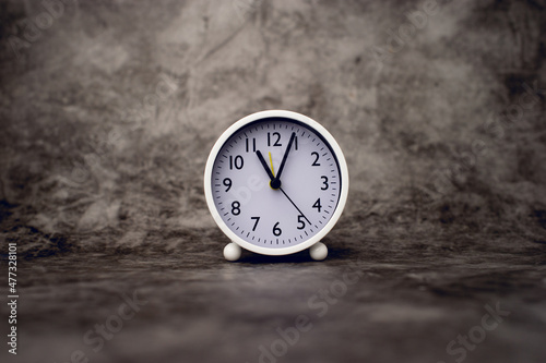 white alarm clock on marble background Time concept and setting an alarm