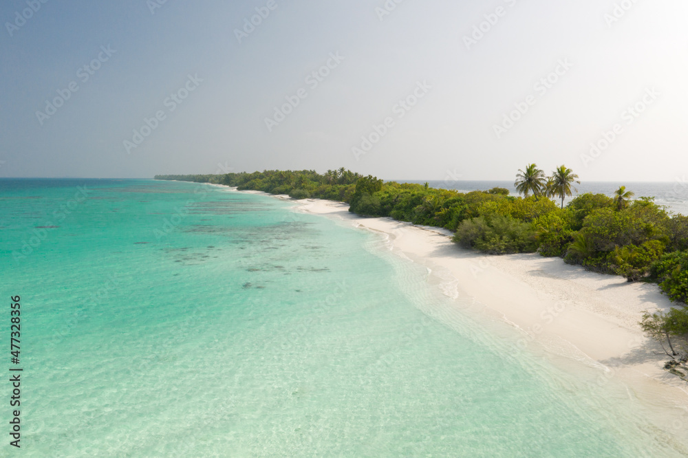Aerial view of a tropical island with a white sand beach and turquoise waters. Dhigurah island, Maldives.