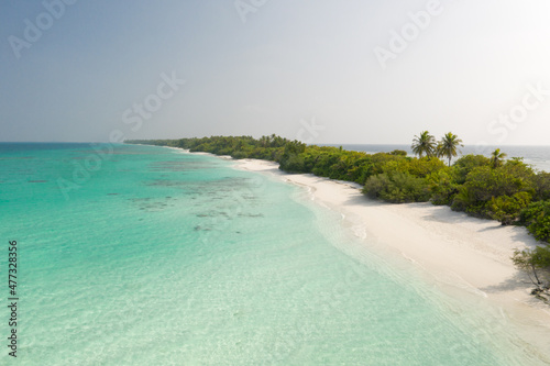 Aerial view of a tropical island with a white sand beach and turquoise waters. Dhigurah island, Maldives.