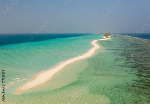 Aerial view of a tropical island with a sandbank, surrounded by turquoise water. photo