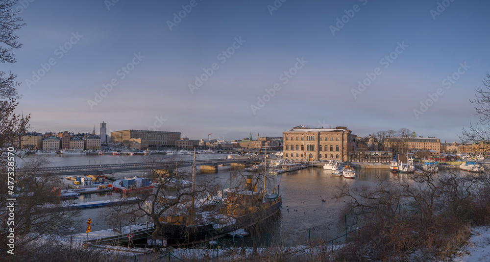Panorama view over the bay Strömmen with piers for commuting boats, the royal castle and art museum a sunny winter day afternoon in Stockholm