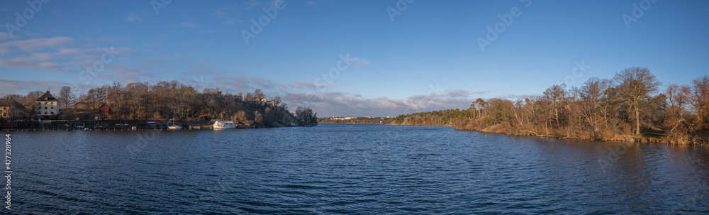 Panorama view over the skyline, icy bay and piers at the castle on the island Drottningholm a snowy winter day in Stockholm