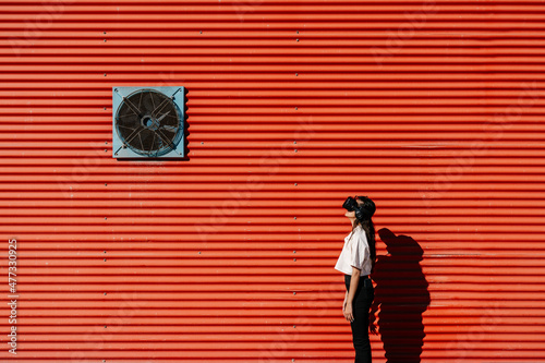 Woman using virtual reality simulator on sunny day