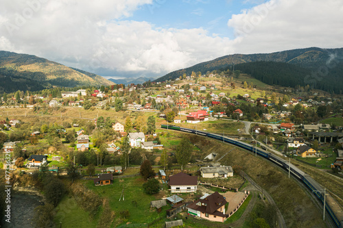 Aerial view of train on bridge and mountain village