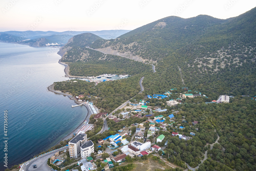 Aerial view of the sea bay and the infrastructure of a small mountain resort on the Black Sea coast.