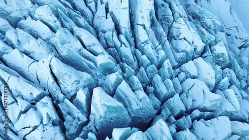 Flying above Blue ice Glacier in Iceland. Deep Crevasses Snowy Ridges. Climate Change Global Warming problem.