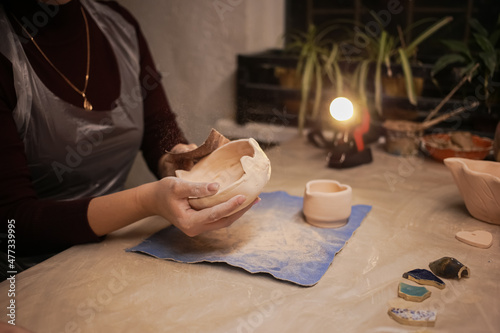 A human sculptor makes a clay product with his own hands photo