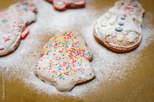 Christmas cookies sprinkled with icing sugar on a baking sheet.