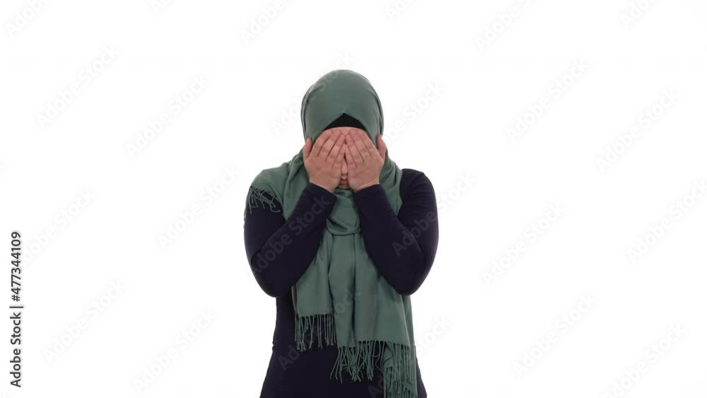 Scared muslim girl covering her face with both hands. Isolated on a white background. Scared muslim girl covering her face with both hands. Isolated on a white background.