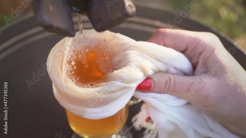 Freshly squeezed apple juice is poured into a glass which is held by a girl with with droplets on the glass. Preparation of fresh apple juice with an old fruit press. Healthy food concept 4k