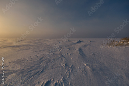 Sunset in vast space on big frozen lake  which looks similar to the icy wasteland