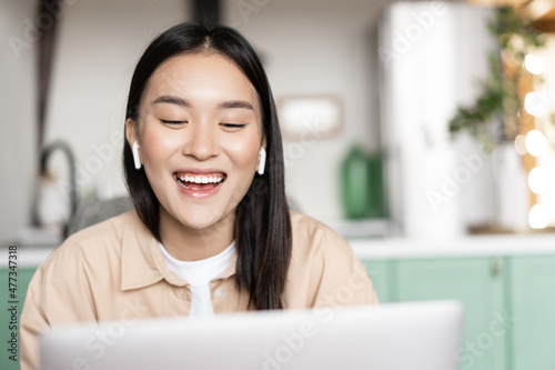 Happy smiling asian girl talking on laptop, video conference. Student studying online webinar, taking distance education course