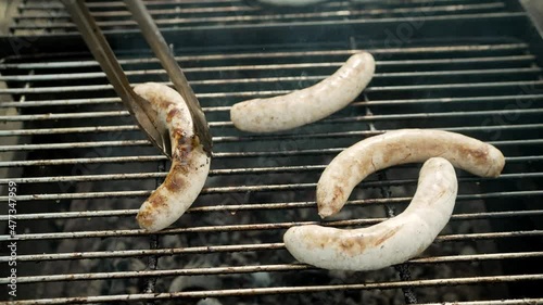 Grilling different kinds of sausages, dry and fresh meat on an open barbeque. Kupaty is grilled in the open air. photo