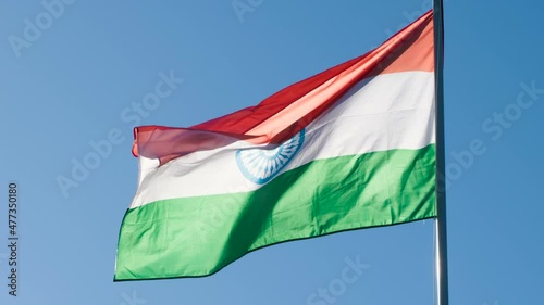 State Flag of India. The Big State Flag is illuminated by the sun and flutters epically in the wind against the blue sky. Slow Motion 120 fps photo