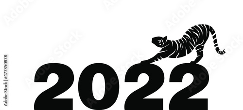 Black and white tiger stretching on top of the number 2022. Happy New Year 2022. Year of the Tiger