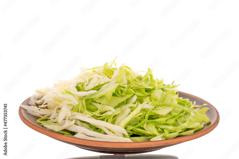 Fresh shredded white cabbage on a clay dish, close-up, isolated on white. Fresh shredded white cabbage on a clay dish, close-up, isolated on white.
