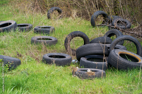 environmental pollution concept  ecology problem. Tires from car wheels are scattered on the grass