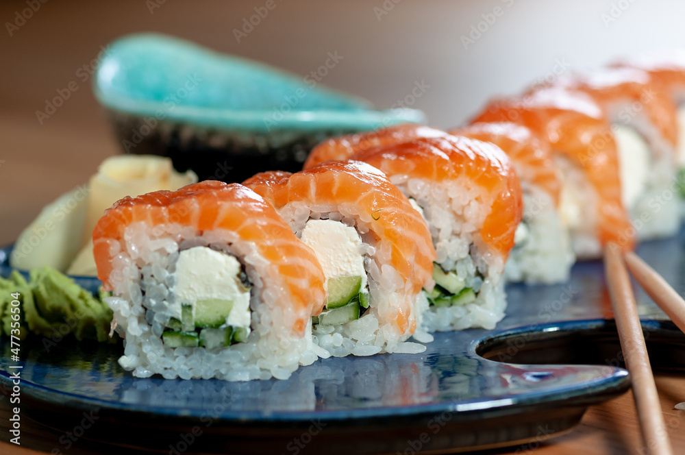 sushi roll philadelphia classic in a blue plate on a wooden table with chopsticks macro photo
sushi roll philadelphia classic in a blue plate on a wooden table with chopsticks macro photo