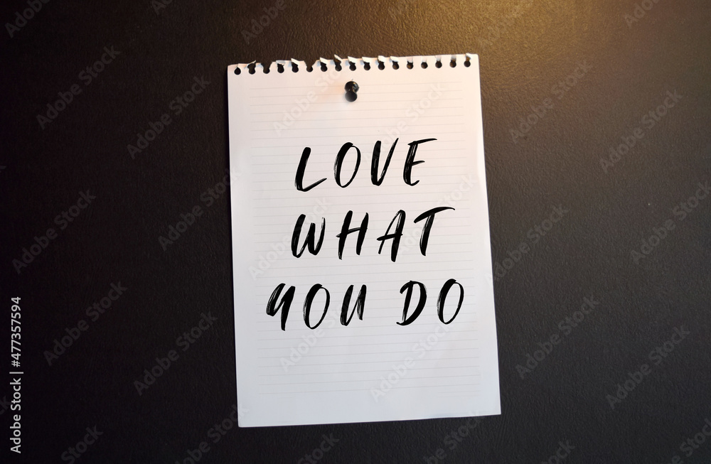 Paper note with LOVE WHAT NOW DO. written on black slate board Paper note with LOVE WHAT NOW DO. written on black slate board